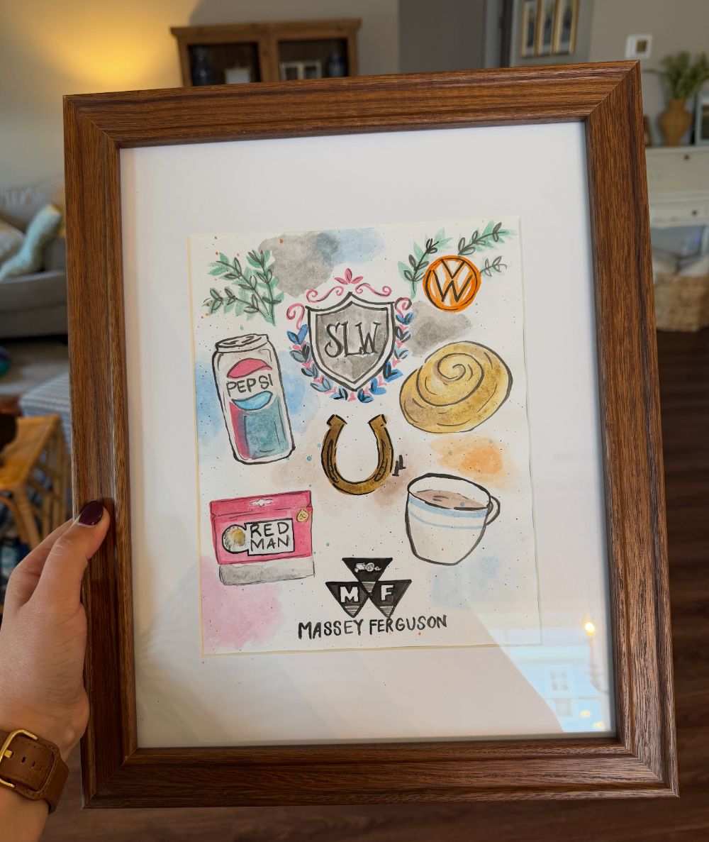 Framed custom watercolor keepsake with an SLW monogram crest surrounded by painted favorites: a Pepsi can, a VW badge, a cinnamon roll, a horseshoe, a Red Man pouch, a cup of coffee and the Massey Ferguson tractor logo